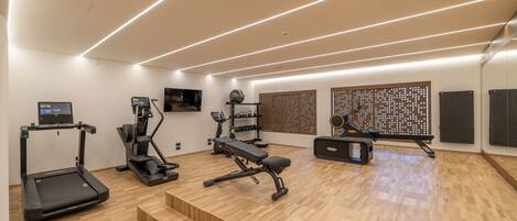 A modern home gym with treadmills, a bench press, and a rowing machine.