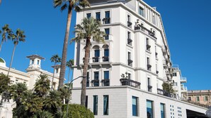 Un hôtel à plusieurs étages, de style architectural classique, doté de balcons et de grandes fenêtres.