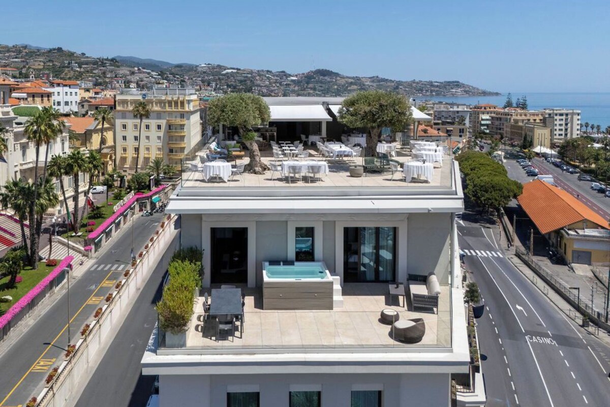 Une terrasse sur le toit, dotée d’un espace extérieur aménagé et d’un jacuzzi, offrant une vue panoramique sur le paysage urbain côtier.