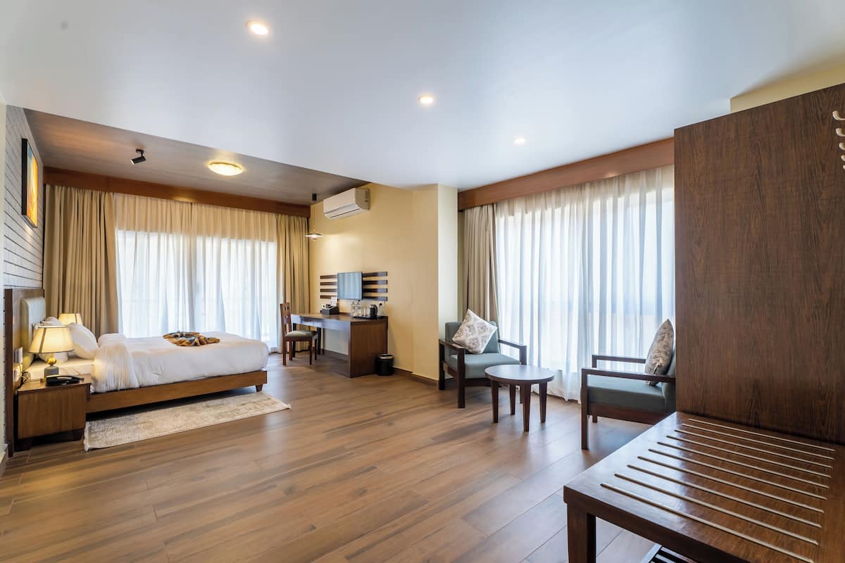 Una habitación de hotel con cama, escritorio, silla y una mesita.
