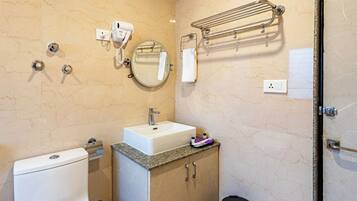A bathroom with a sink, mirror, towel rack, and a hairdryer on the wall.