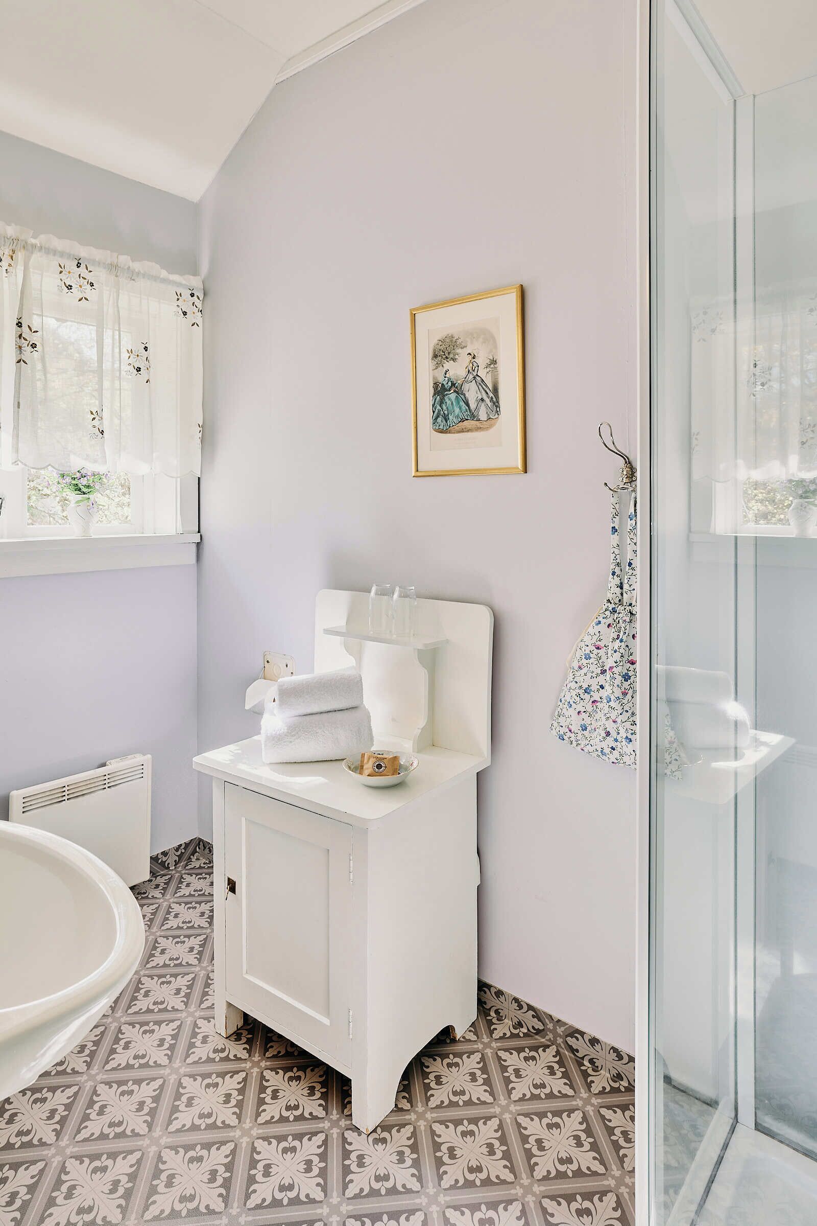 Un bagno con un mobile lavabo bianco, una vasca da bagno e un box doccia in vetro.