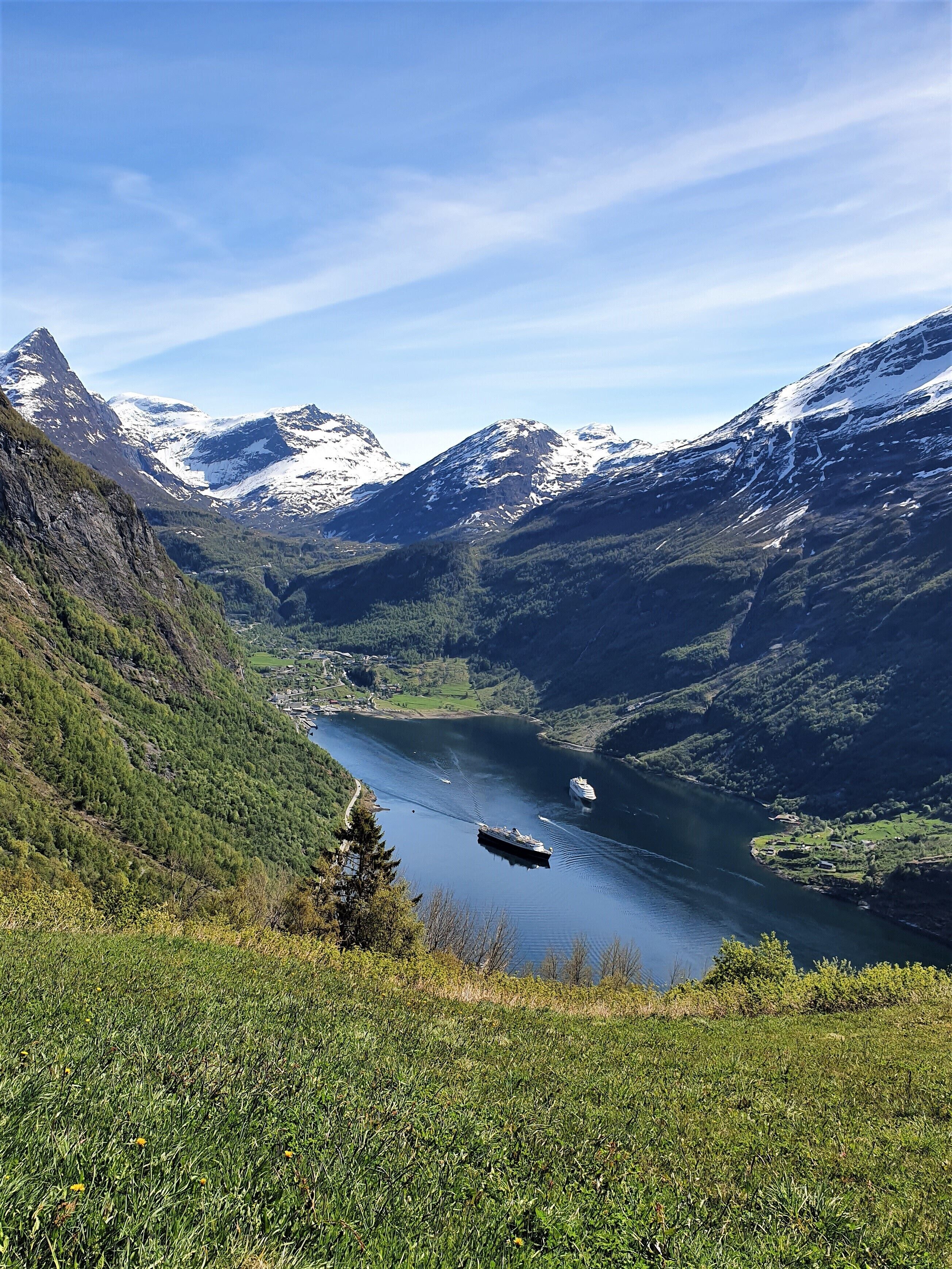 Un paisaje montañoso con un lago y un crucero.