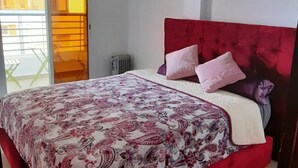 A bedroom with a red headboard, a patterned bedspread, and two pillows. - 2-bedroom apartment for 6 people (Tanger)
