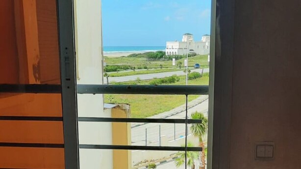 A view from a balcony with a clear sky, a road, and a building in the distance. - 2-bedroom apartment for 6 people (Tanger)