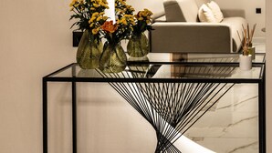 Un salon moderne avec une table basse en verre, un canapé et un mur incurvé.