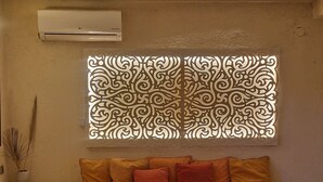 Un soggiorno moderno con un divano, un tappeto decorato e un pannello murale ornamentale.