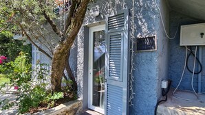 Una casa con una puerta, un árbol y un enchufe en la pared.