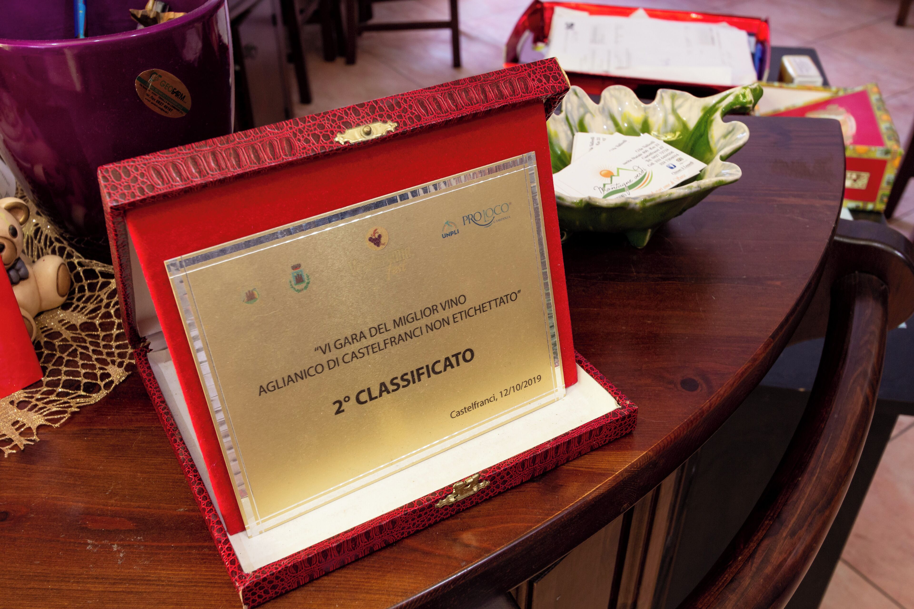 Een ingelijst erkendingsbewijs op een houten tafel.