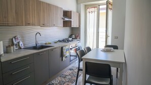 Een moderne keuken met houten kastjes, een spoelbak en een zithoek met stoelen en een tafel.