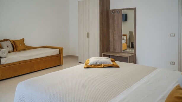 Een slaapkamer met een bed, een kledingkast en een spiegel.