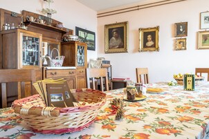 Un comedor con mantel floral, muebles de madera y cuadros en la pared.