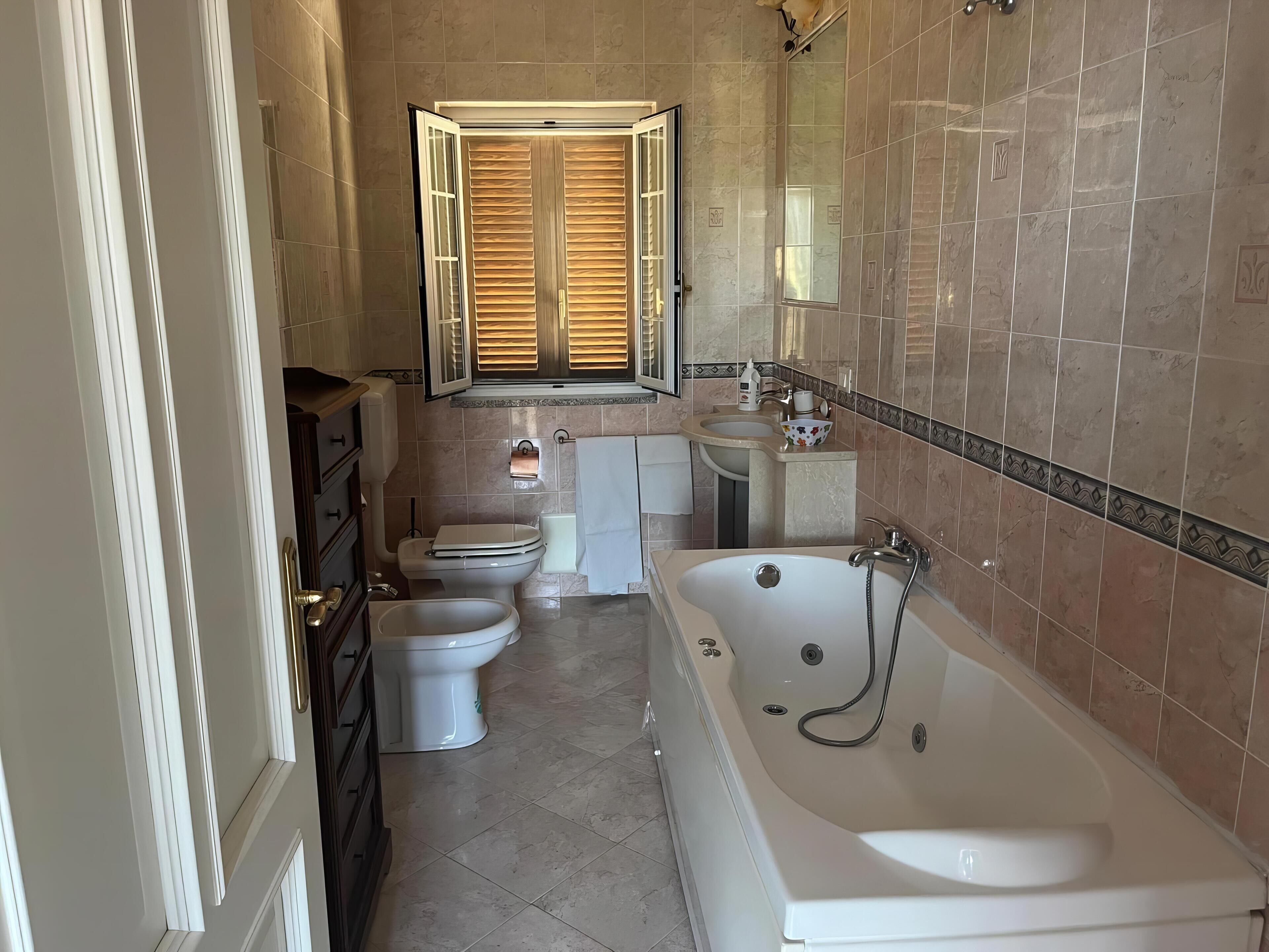 Un baño con bañera, inodoro y lavabo.
