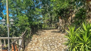 A stone pathway leading uphill, flanked by greenery and a wooden fence. - Hssoverato (Soverato)