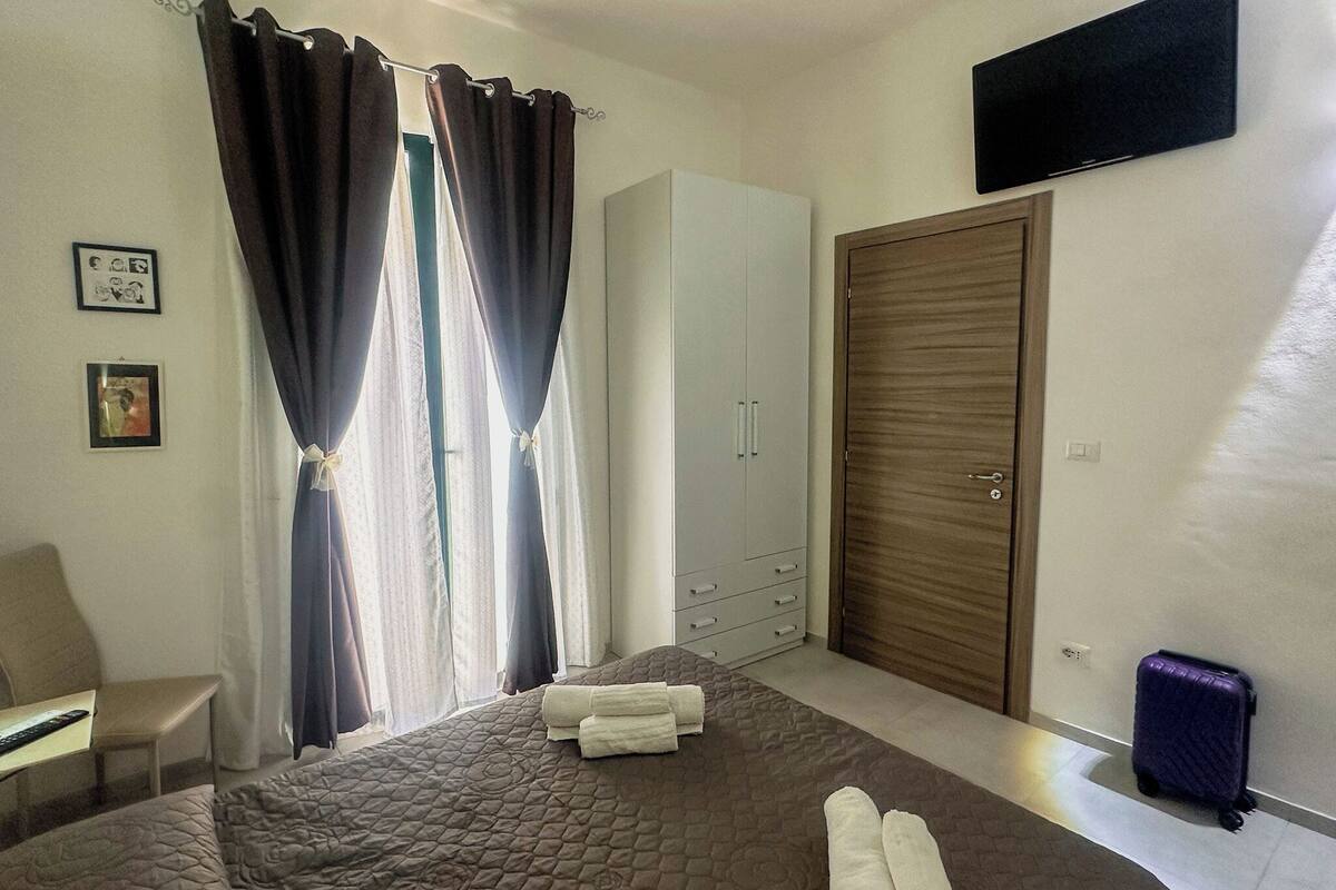 Une chambre d’hôtel comprenant un lit, une armoire, un bureau et un téléviseur.