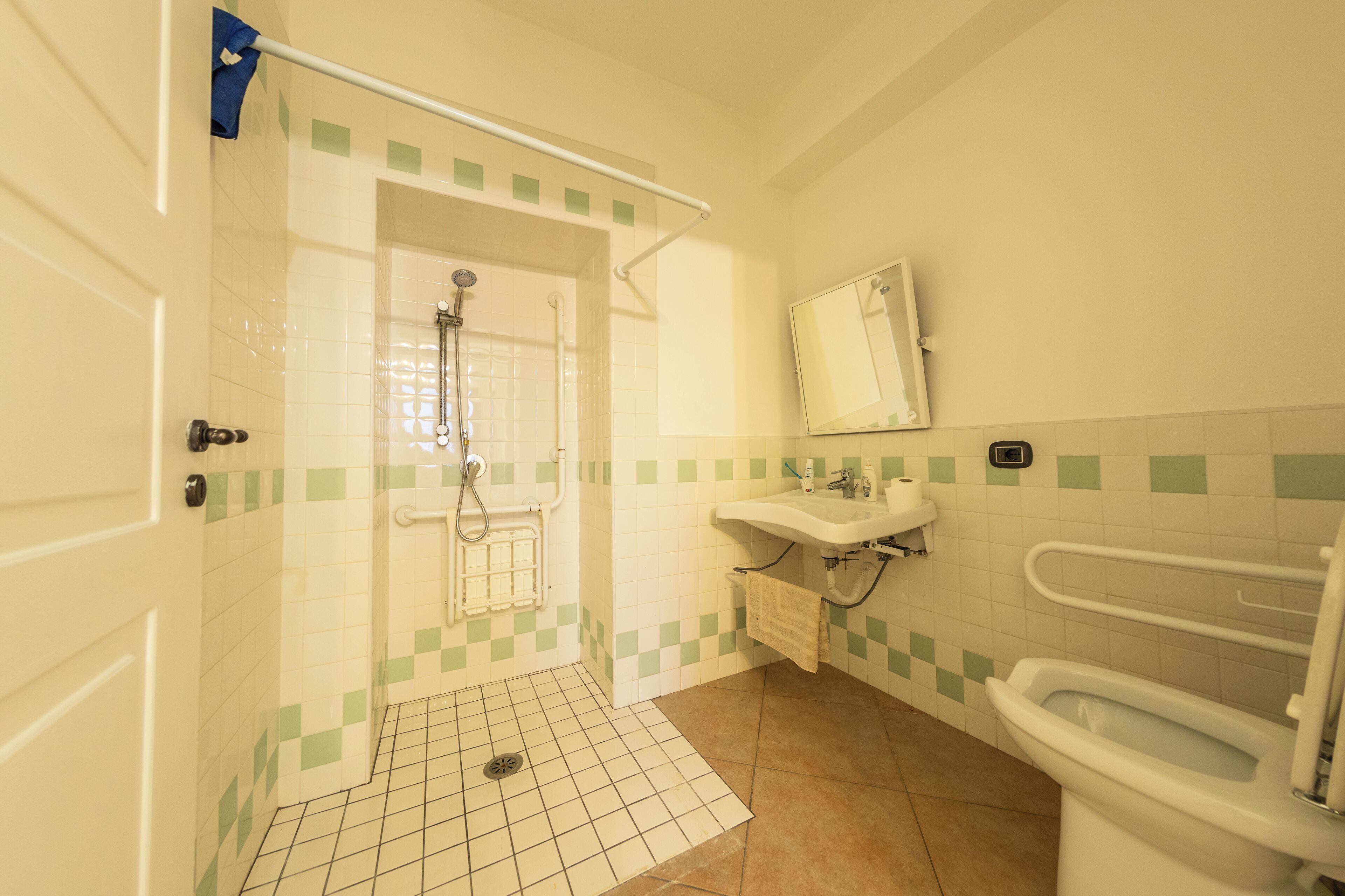 Un baño con ducha, lavabo, inodoro y espejo.