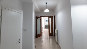 A hallway with a white door, a radiator, and a ceiling light. - Villa D'Angelo (Casalbordino)