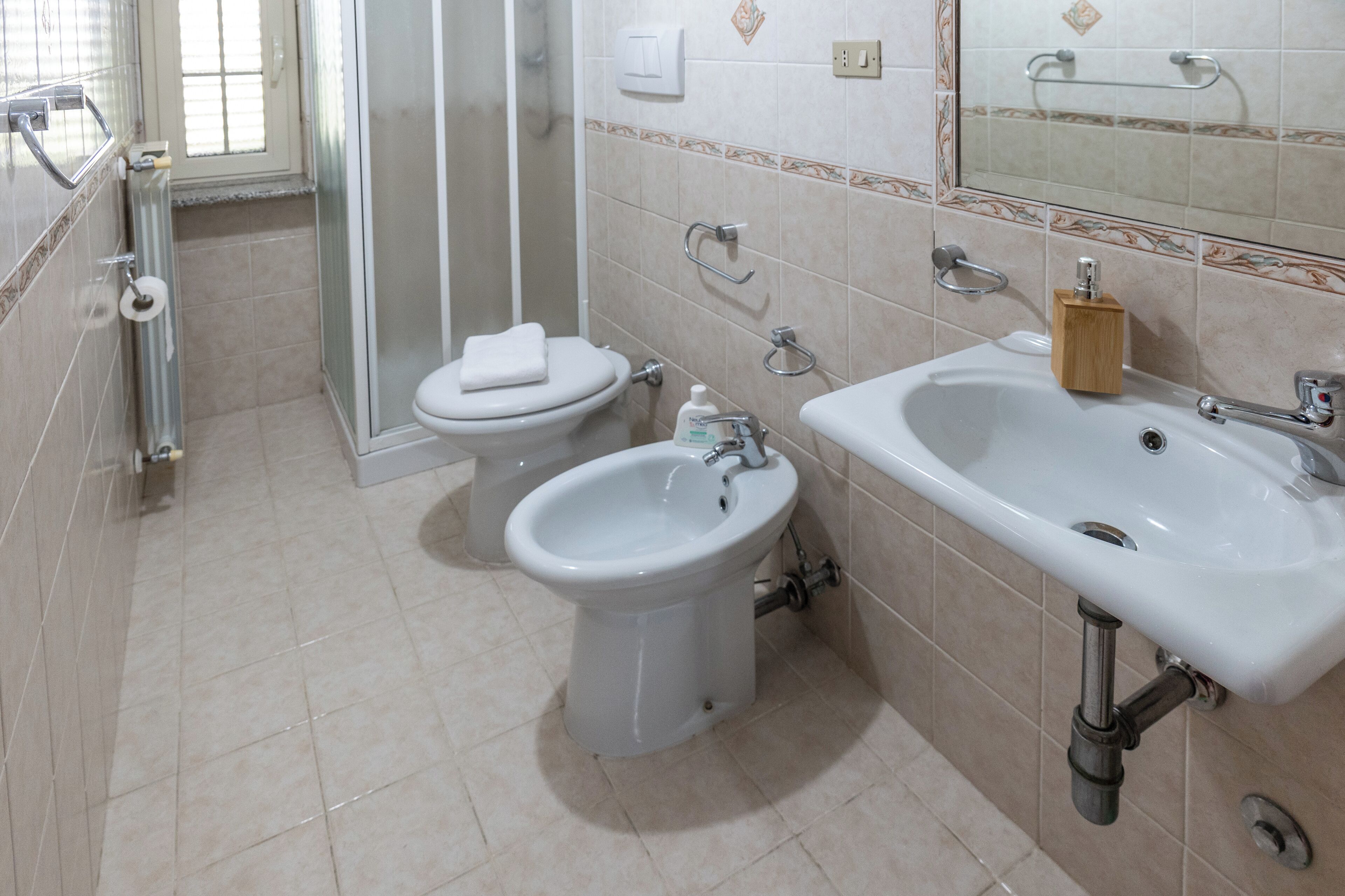A bathroom with a toilet, bidet, and sink.