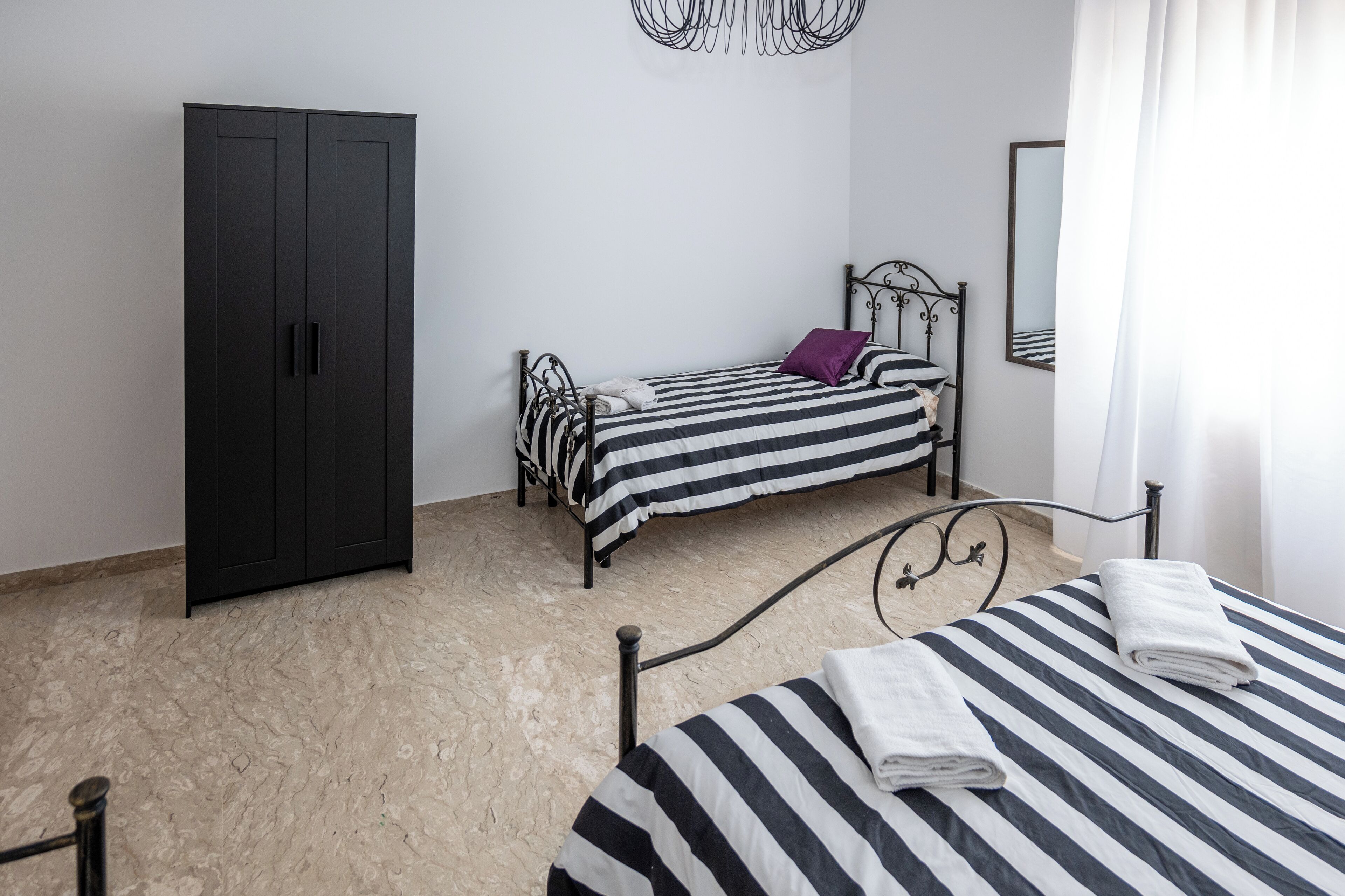 Une chambre à coucher avec un lit, une armoire et un miroir.