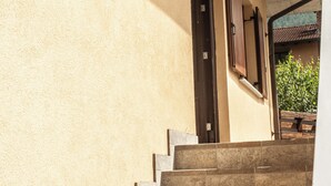 A set of stone steps leading to a door with a light fixture above it. - Appartamento Edolo, Bilocale & Monolocale (Edolo)