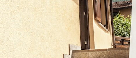 A set of stone steps leading to a door with a light fixture above it.