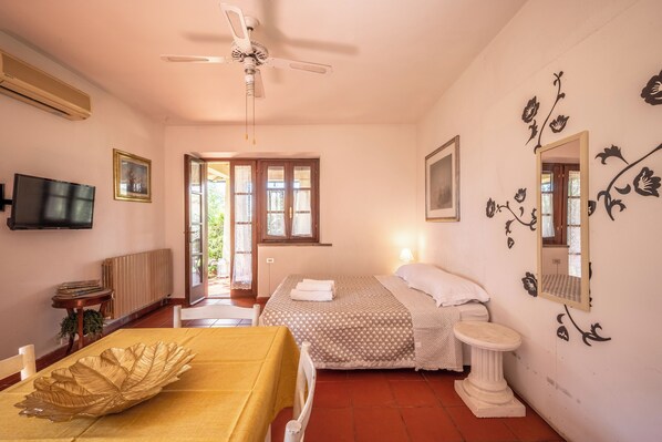 A bedroom with a bed, bedside table, and a ceiling fan.