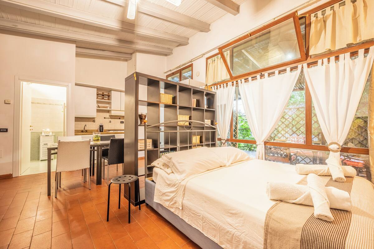 Een slaapkamer met een bed, een bureau en een wandplank.