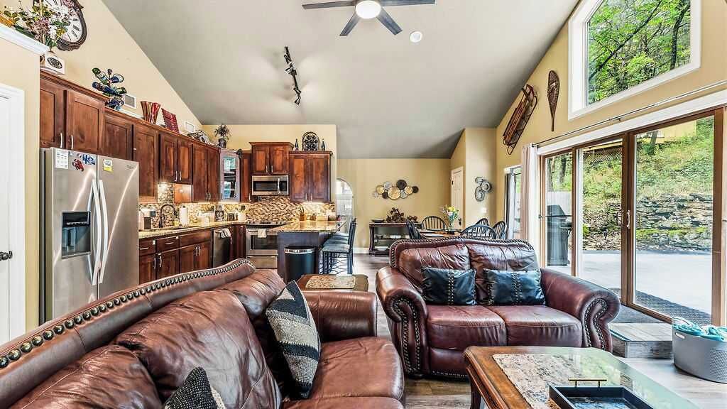 A spacious living room with a large leather sofa and a dining area with a table and chairs.