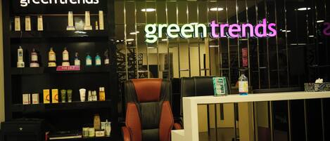 A store interior with shelves of skincare products and a neon sign reading "green trends".