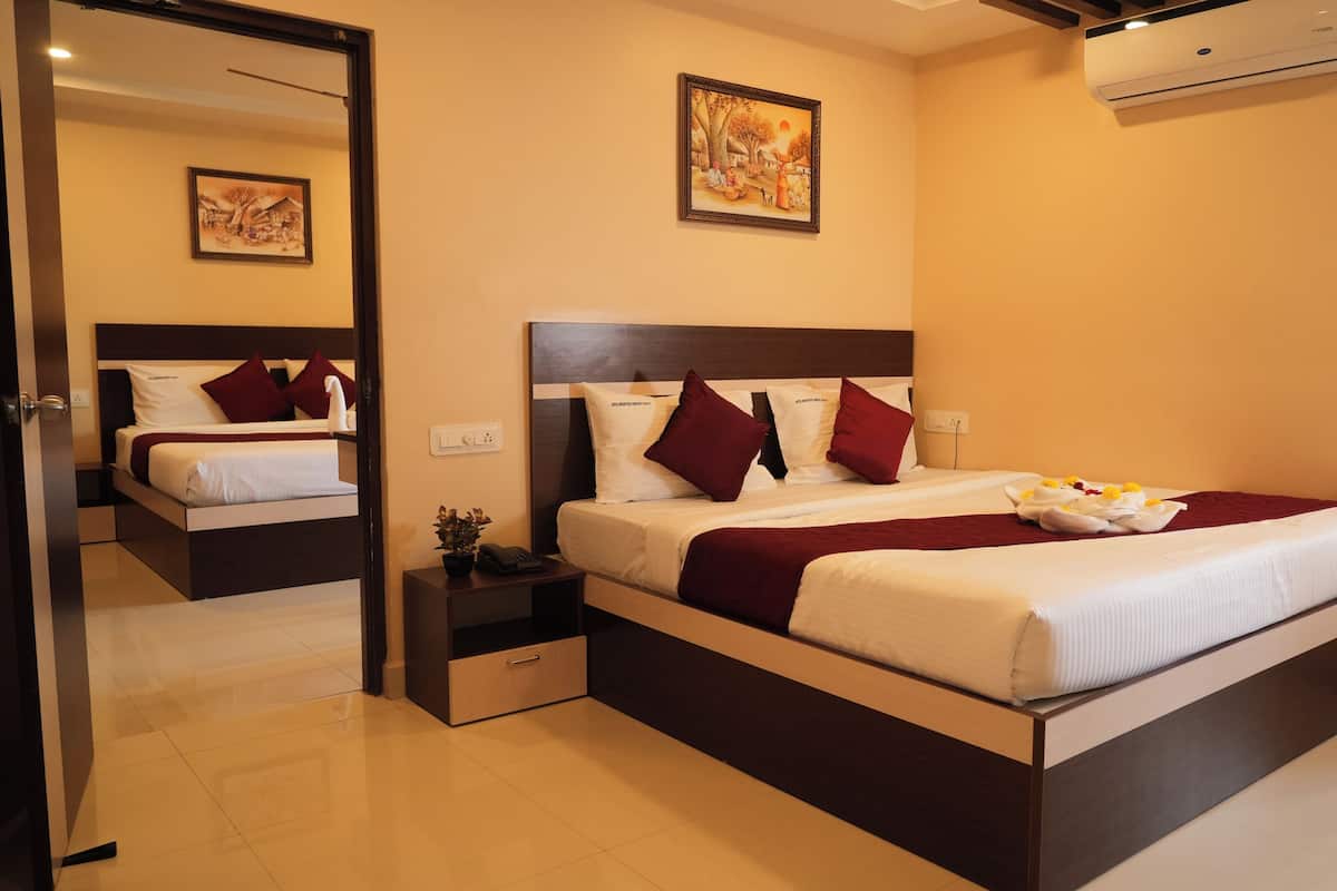 Quarto de hotel moderno com uma cama grande, uma mesinha de cabeceira, um espelho e um quadro na parede.