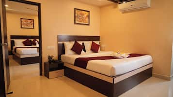 A modern hotel room with a large bed, a bedside table, a mirror, and a painting on the wall.