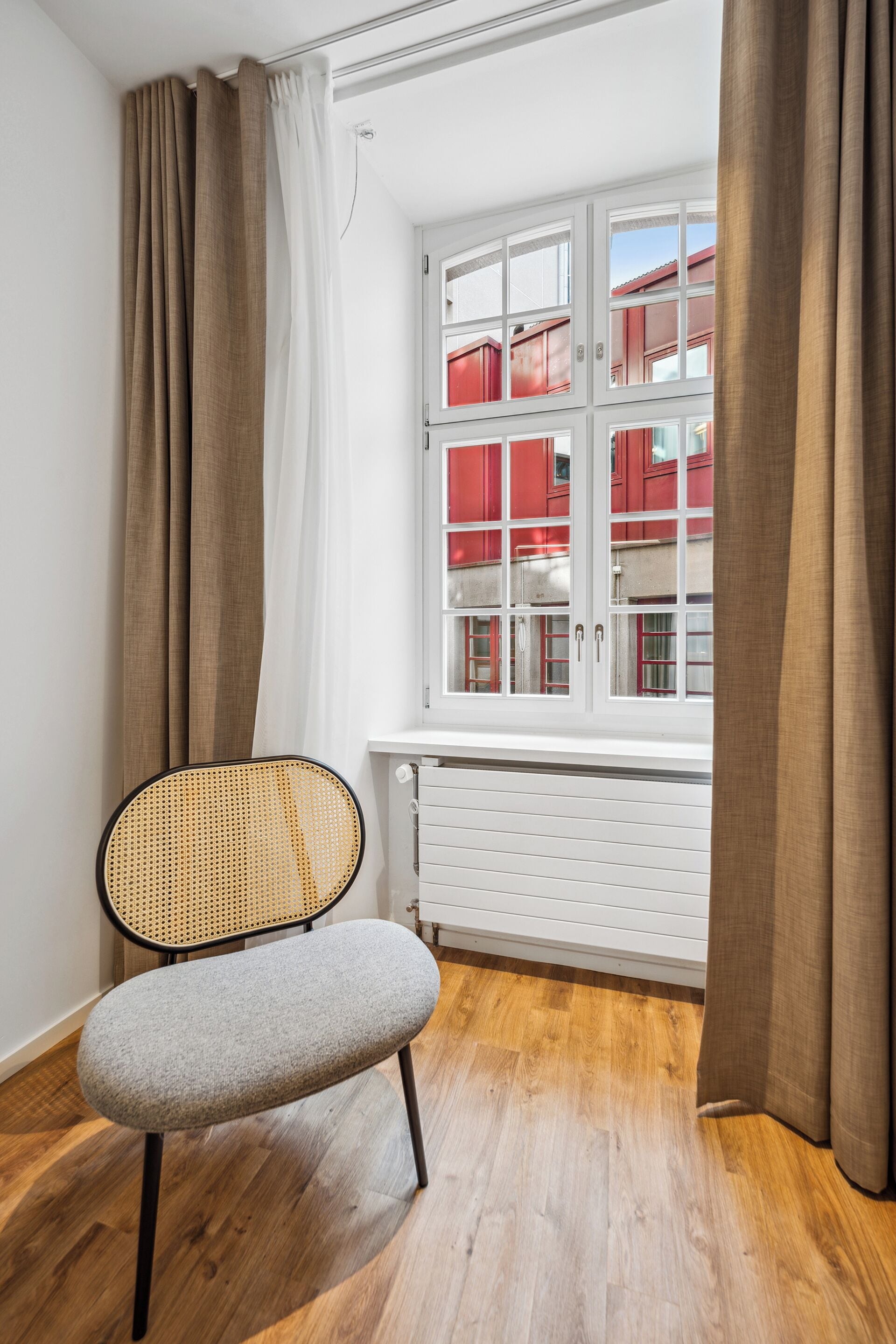 A room with a window, a radiator, and a chair.