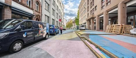 Una calle con vehículos estacionados y edificios.