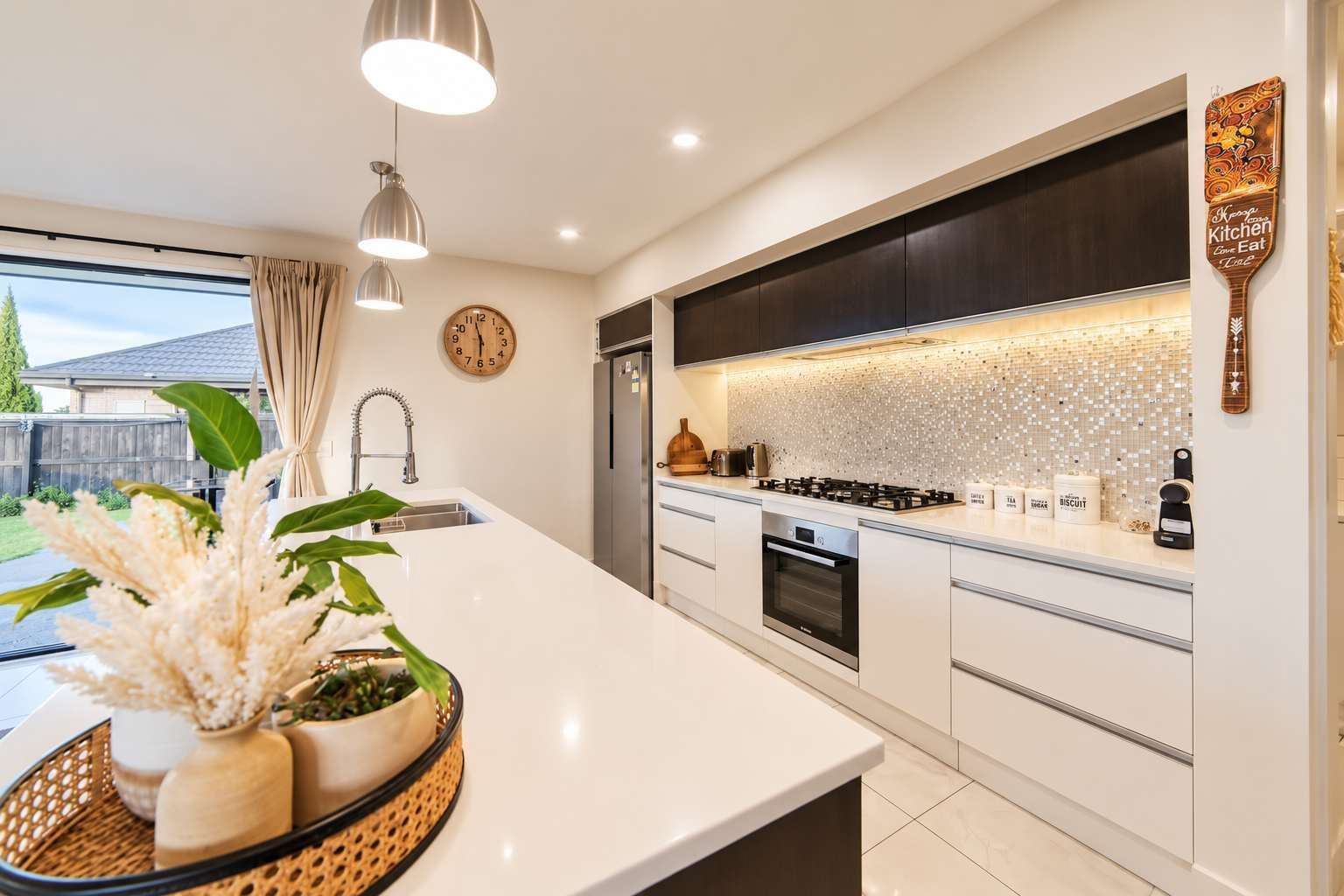 A modern kitchen with a large island, stainless steel appliances, and a decorative backsplash.