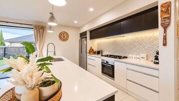 A modern kitchen with a large island, stainless steel appliances, and a decorative backsplash.