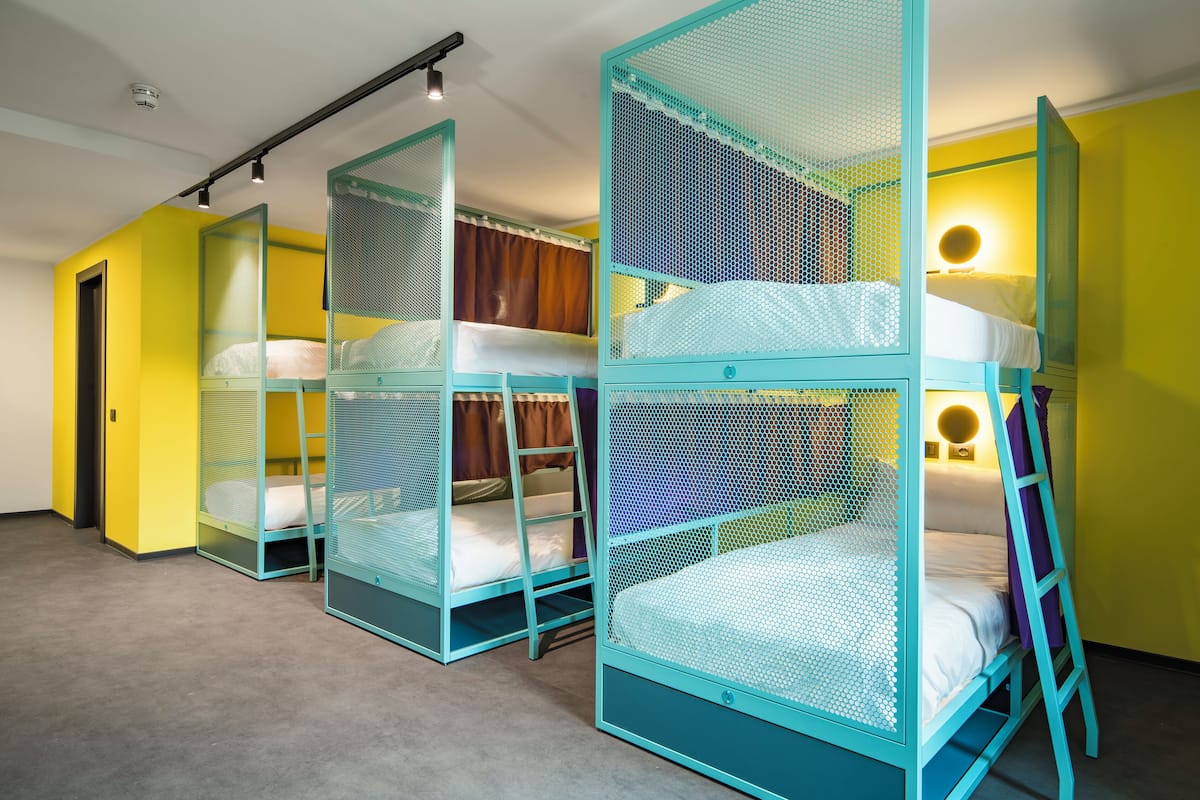 A room with bunk beds, a ladder, and a door.