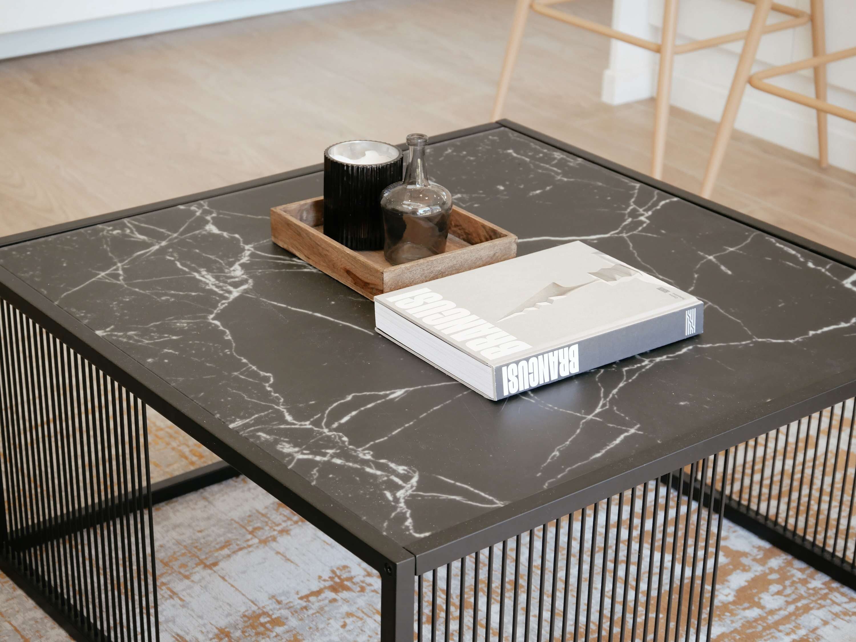A marble-topped table with a book titled "FRANCOIS" and a small wooden tray with two bottles.