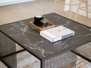 A marble-topped table with a book titled "FRANCOIS" and a small wooden tray with two bottles.
