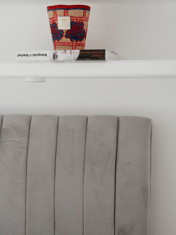 A white shelf with a decorative vase and books.