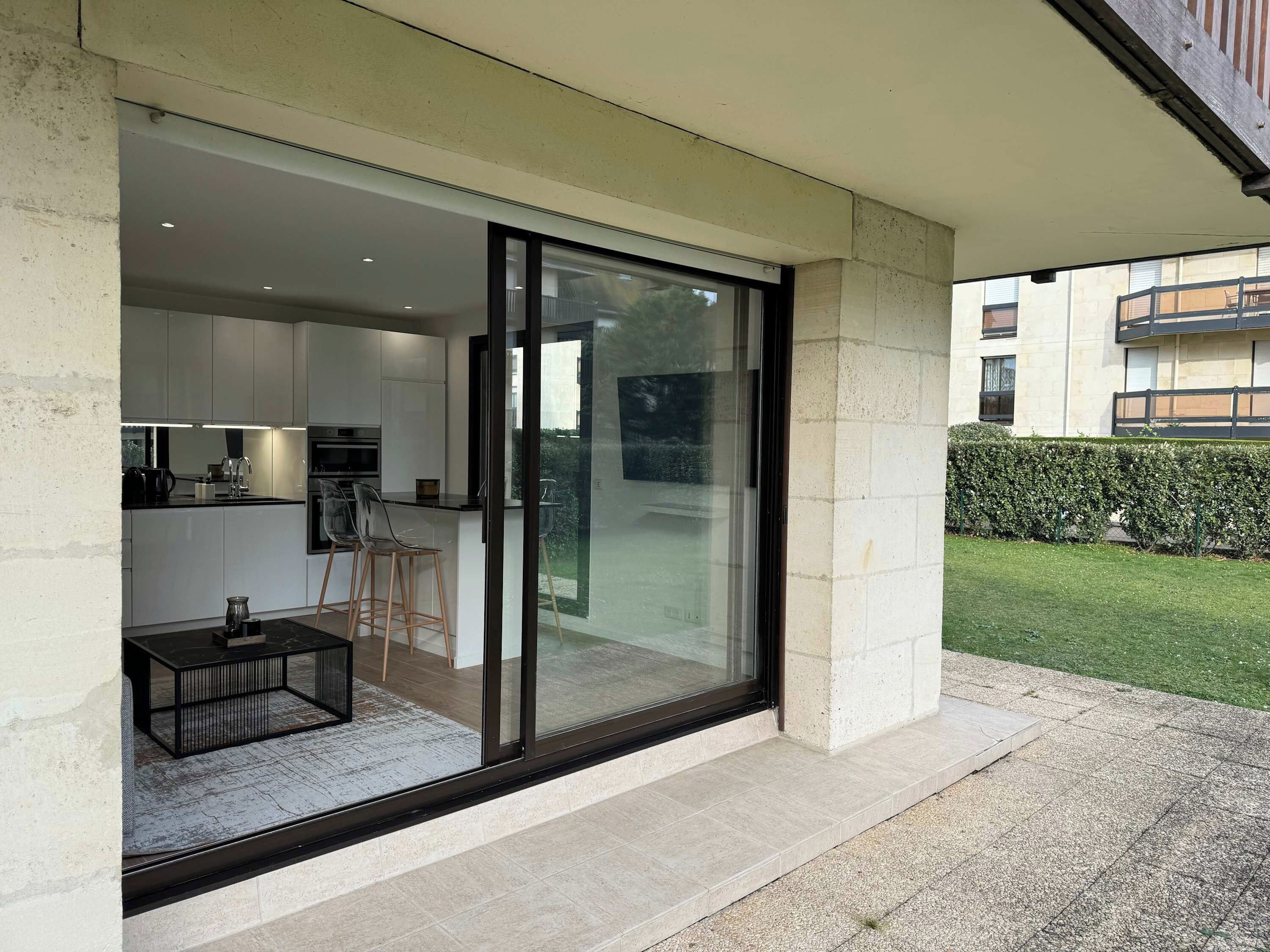 A modern kitchen with a glass door leading to a patio area.