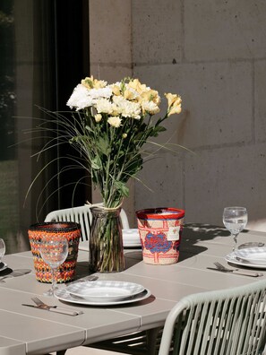 A table set for dining with a vase of flowers, two decorative baskets, and a glass of water.