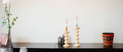 A dining table set with plates, glasses, and a vase with flowers.