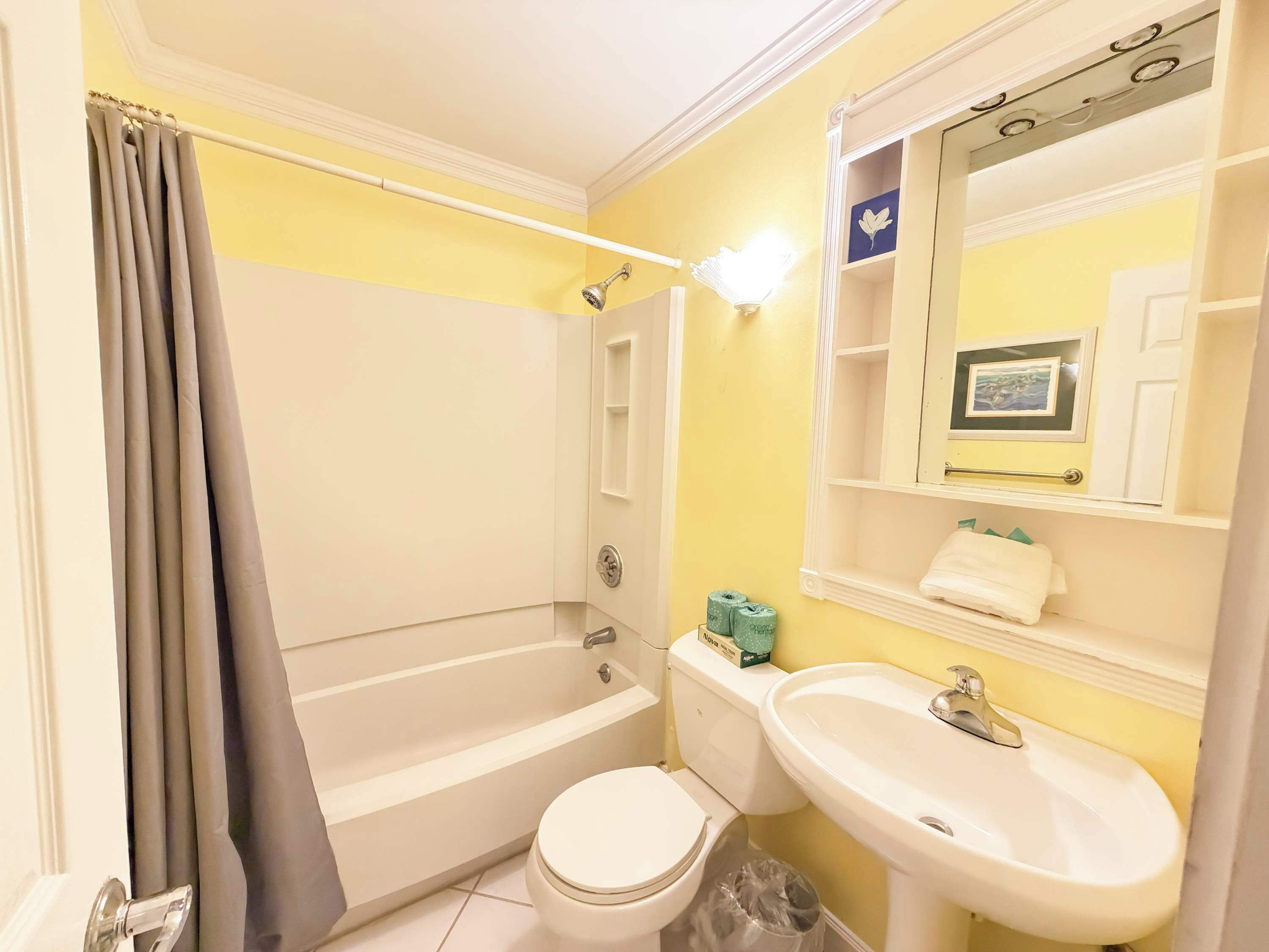 A bathroom with a bathtub, toilet, and sink.