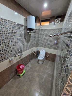 Une salle de bain équipée de toilettes, d’une douche et d’un lavabo.
