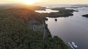 An aerial view of a coastal area with a road leading to a parking area and a marina with boats. - Luxury Glamping Pod at Carrickreagh Bay, Enniskillen (Enniskillen)