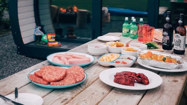 A dining table set with various dishes and drinks in front of a circular structure with a glass door, overlooking a natural landscape. - Luxury Glamping Pod at Carrickreagh Bay, Enniskillen (Enniskillen)