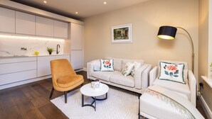 A modern living room with a sofa, armchair, and coffee table.