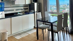 Eine moderne Küche mit Essbereich, großen Fenstern und Blick auf die Stadt.