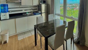 Eine moderne Küche mit Essbereich, großen Fenstern und Blick auf die Stadt.
