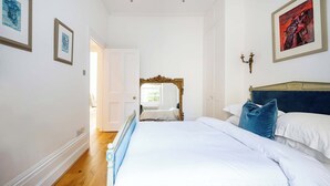 A bedroom with a bed, a mirror, and framed artwork on the walls. - Highlife and Islington - by Out of Office Lifestyle (Greater London)